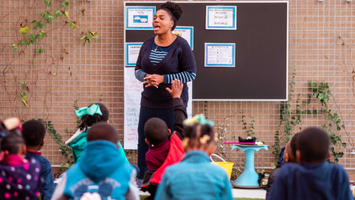 Teacher speaking to their classroom with a diverse group of students